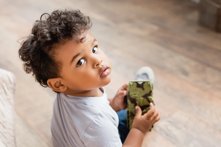 A young boy plays with his toys during bedtime shenanigans. 