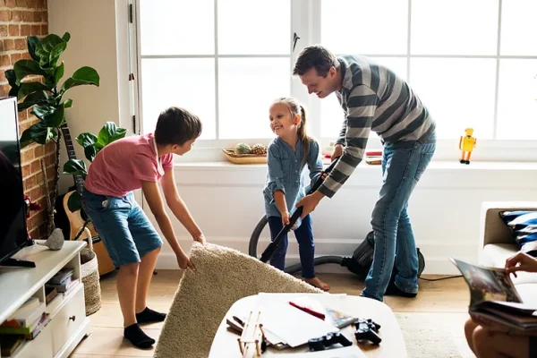 Dad works with his two children to do quick cleaning tasks.