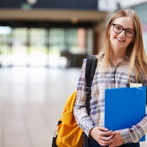 A high school girl standing in the hallways of a high school for a story on applying to college