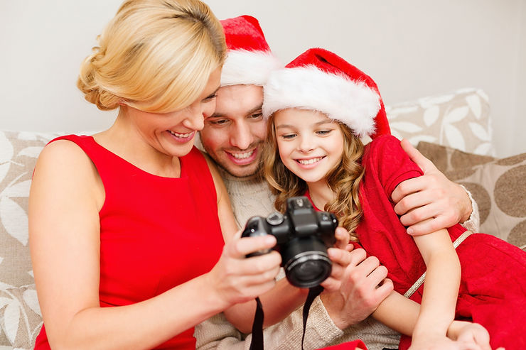 A family is looking into their camera at their Christmas family photoshoots.