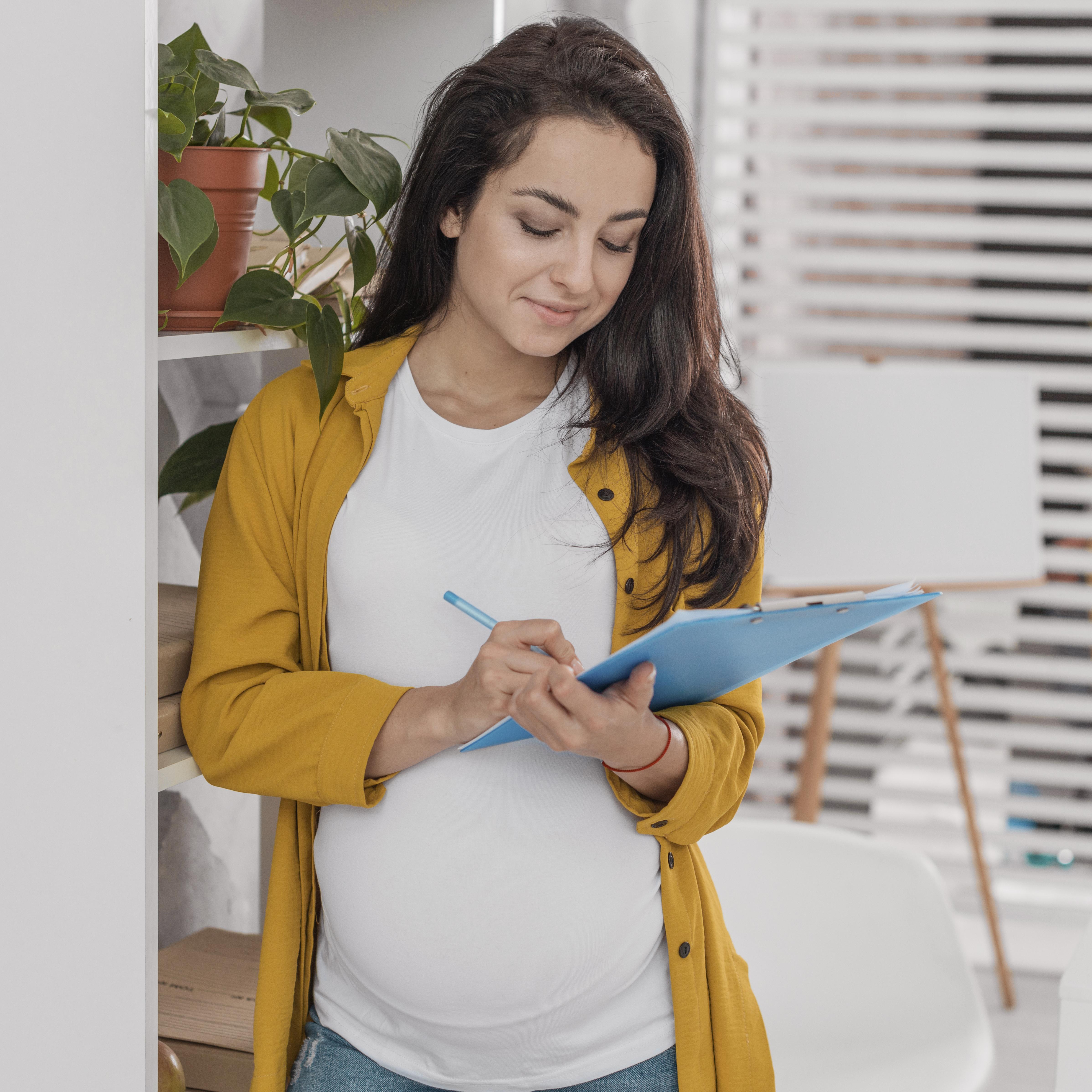 A pregnant mom with a clipboard prepares for her First Trimester of pregnancy.